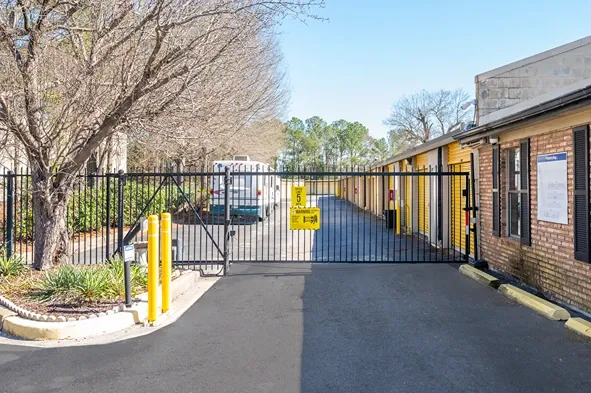 Secure gated entry to storage facility with keypad access and adjacent office building